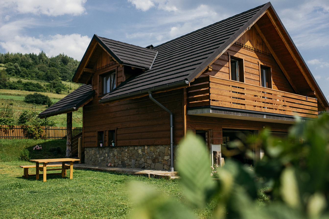 Drewniany Domek na Śmigowskim na zboczu wzgórza w Piwnicznej-Zdroju, otoczony zielenią Beskidu Sądeckiego