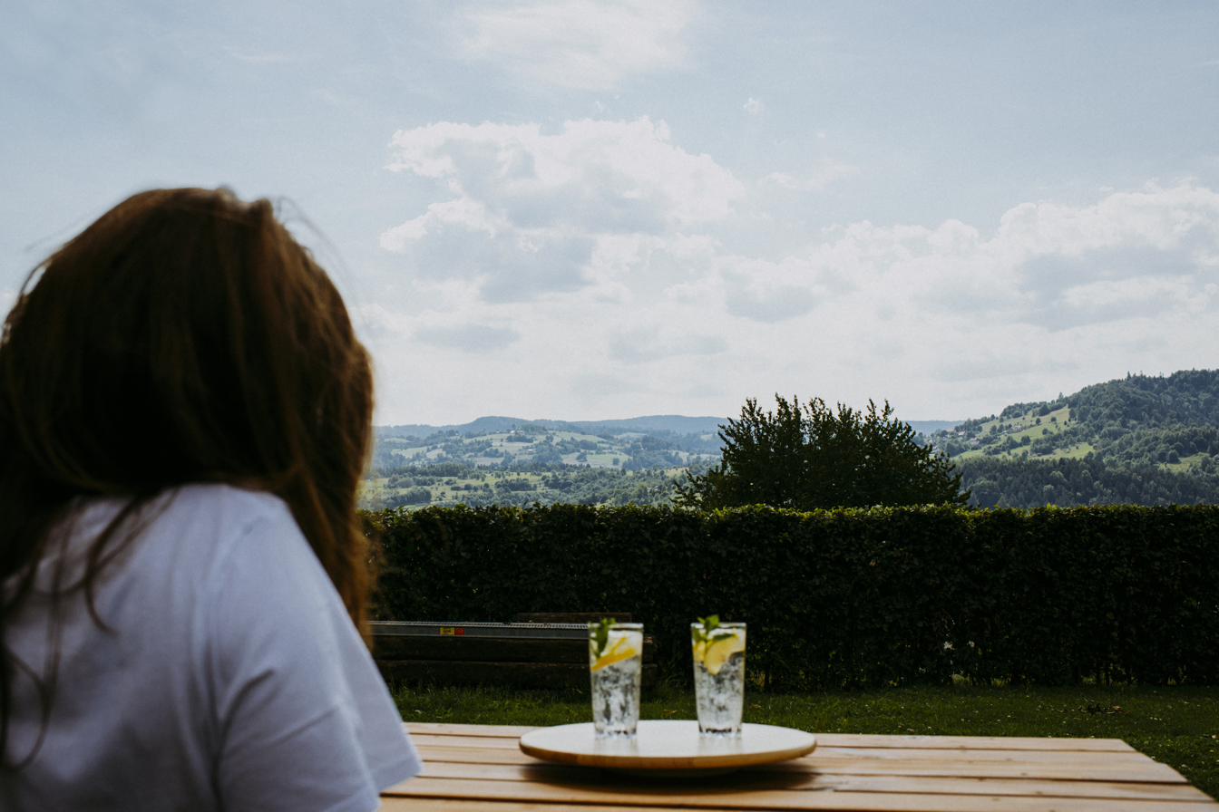Domowa lemoniada na stole w ogrodzie i widok na zielone wzgórza